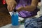 Thai old woman working sewing fabric mask and use alcohol gel cleaning hand and product before start work at workshop in house at