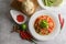 Thai papaya salad in a white plate with Sticky rice in wicker basket bamboo and dried shrimp