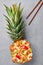 Thai Pineapple Fried Rice or Kao Pad Sapparod dish in pineapple bowl on gray backdrop. Thailand meal. Asian Food