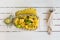 Thai rice with chicken in pineapple plate with vegetables on the wooden table. horizontal top view, fork and knife near it