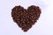 Thai roasted coffee beans in shape of heart on white background