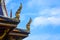 Thai rooftop architecture, haghgss ridges ornament on the sloping edges of a gable with blue sky and clouds background