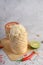 Thai sticky rice in a woven bamboo basket on a wooden panel with chilies, lime, and garlic