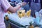 Thai street food. Woman buying small peeled and sliced pineapples at a local market.