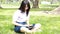 Thai student teen beautiful girl using her tablet sitting in park.