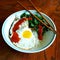 Thai style breakfast with fried egg and greens over rice