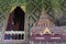 Thai-style decorated window and gilded wall, with scripture box on carved wooden shelf at Wat Mahathat Temple