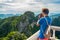 Thai traveler takes a photo of mountains covered with the jungle from the Tiger Cave Mountain Temple in Krabi, Thailand