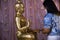 Thai travelers women people travel visit and rite ritual merit cover thin gold leaf on buddha statue for respect praying blessing