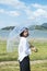 Thai woman holding transparency umbrella among nature