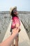 Thai woman lead someone by the hand and hold on the walkway bridge