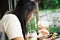 Thai woman sitting relaxed playing smartphone and drinking frappe chocolate in coffee shop