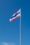 Thailand flag on flagstaff with blue sky background