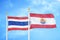 Thailand and French Polynesia two flags on flagpoles and blue sky