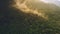 Thailand jungle sunset aerial view. Green tree tops on mountains hillside in mist in golden sunset