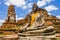 Thailand, Stupa and Buddha sculpture with orange sash in Ayutthaya