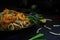 Thailand traditional cuisine, Pad thai, dried noodle, fried noodles, shrimp and seafood, street food, dark food photography