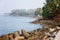 Thangassery Lighthouse cliff surrounded by palm trees and big sea waves on the Kollam beach. Kerala, India