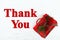 Thank You message with red Christmas present with pine cones