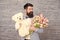 Thank you. Spring gift. Bearded man hipster with spring flowers. Bearded man with tulip bouquet and bear. Womens day