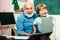 Thank You Teacher. Friendly child boy with old mature teacher in classroom near blackboard desk. Teacher is skilled