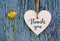 Thank You or thanks greeting card with flower and decorative white heart on blue wooden background.International Thank You Day.