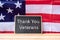 Thank You Veterans text written in chalkboard with flag of the United States of America on wooden background.