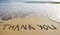 Thank you word drawn on the beach sand