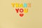 THANK YOU words and red heart on wooden letters on yellow background