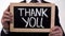 Thank you written on blackboard in businessman hands, donation appreciation