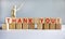`Thank you` written on wood blocks. Business concept. Wooden model of human. Copy space. Beautiful white background