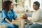 Thankful aged woman taking pills from a caring medical attendant