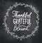 Thankful grateful blessed inspirational design with floral hand drawn wreath and chalk background