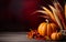 Thanksgiving background with pumpkins, corn cobs, maple leaves and fall berries on dark bokeh lights red background.