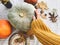 Thanksgiving concept. Hand in yellow sweater holding pumpkin and nuts,  flowers, fall leaves on rustic table, flat lay. Fall decor