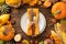 Thanksgiving day concept. Top view photo of plate knife fork napkin candles raw vegetables pumpkins apples corn zucchini pattypans