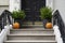 Thanksgiving decorated front door with pumpkins and potted plants. Autumn season