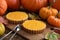 Thanksgiving dessert for two. Open homemade pumpkin pies decorated with bright orange pumpkins and marple leaves