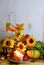 Thanksgiving or fall background with gourds, candles,  autumn leaves, twigs and sunflowers on a rustic wooden background