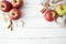 Thanksgiving or fall background with red apples, cinnamon, white candle and dried flowers on white wood background.