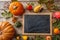 Thanksgiving flat lay with colorful pumpkins, fruits and blank blackboard on rustic wooden background, copy space, top view