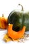 Thanksgiving green and orangel Pumpkins with slice and seeds on autumn leaves