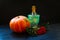 Thanksgiving and Halloween autumn composition. Pumpkin, rowan and green decanter, dark cold background. Composition with