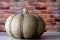 Thanksgiving Metal Pumpkin with abstract ornaments against a red brick wall.  Holiday concept still life