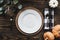 Thanksgiving place setting with empty plate over a wood background