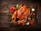 Thanksgiving turkey background, close up. Roasted turkey garnished with vegetables and herbs on wooden table. Festive dish served