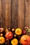 Thanksgiving vertical banner with pumpkins, sea buckthorn branches, apple, berries, walnuts on wooden desk. Flat lay, top view,