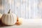 Thanksgiving white pumpkin and candle decorations on a white painted wood table. Halloween, Thanksgiving party concept