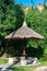 Thatch canopy with stone benches the background of an overgrown wall