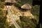 THATCH COVERED SHELTERS AT THE END OF SUSPENSION BRIDGE OVER ORIBI GORGE